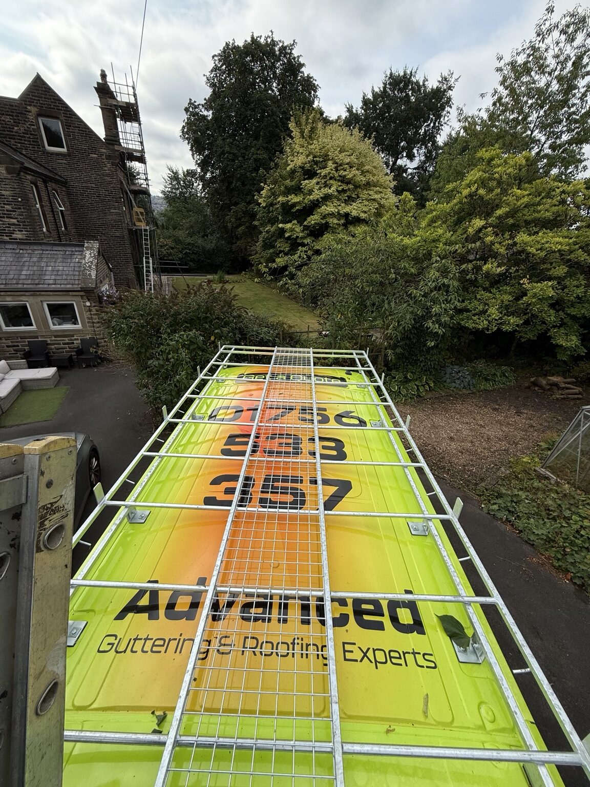 Advanced Roofing & Guttering van and access equipment on a stone property project