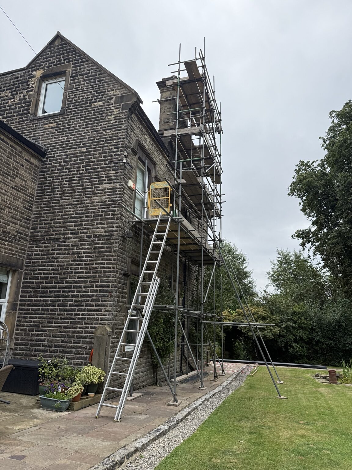 Scaffolding around a stone property for chimney and roof repair work