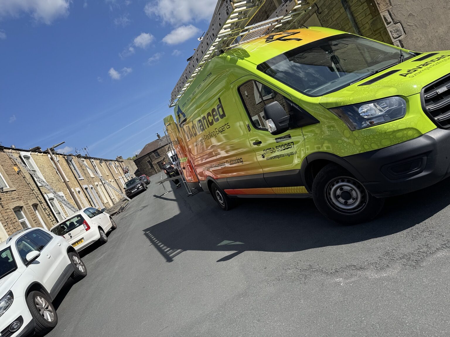 Advanced Roofing & Guttering van set up outside a stone property